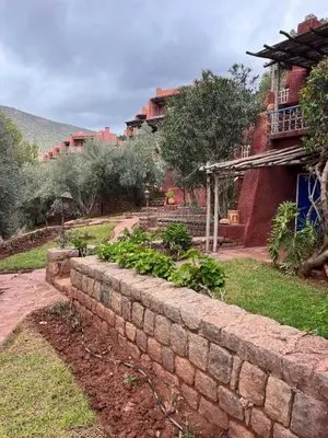 a brick retaining wall in front of a house at Atlas AGUELMAM in Bine el Ouidane