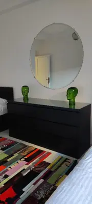 a bedroom with a dresser with a mirror on the wall at APPARTEMENTS NIA CONFORT, Plein centre ville, avec TERRASSE in Fès