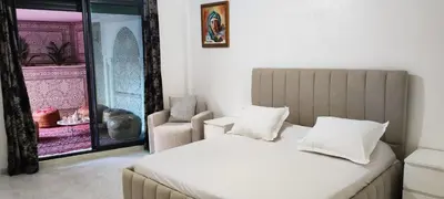 a bedroom with a bed and a chair and a window at APPARTEMENTS NIA CONFORT, Plein centre ville, avec TERRASSE in Fès