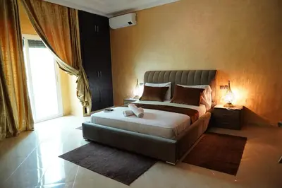 a bedroom with a large bed and a large window at La Palmeraie De Moulay Yacoub in Moulay Yacoub