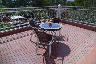 a patio with a table and chairs on a balcony at La Palmeraie De Moulay Yacoub in Moulay Yacoub