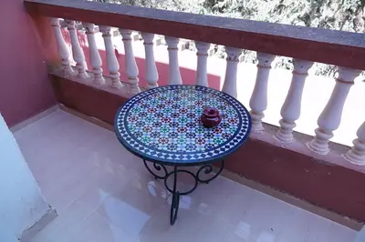 a table with a bowl on top of a balcony at La Palmeraie De Moulay Yacoub in Moulay Yacoub
