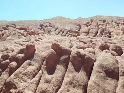 a field of rocks with mountains in the background at Hotel restaurant ait saderat in Boumalne