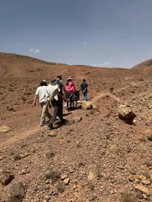 a group of people walking on a rocky hill at Hotel restaurant ait saderat in Boumalne