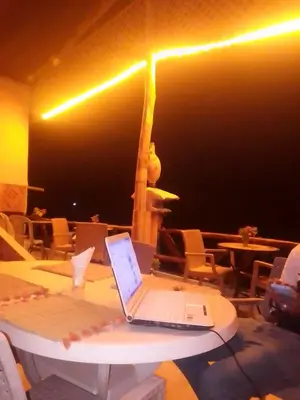 a laptop sitting on a table in a restaurant at Hotel restaurant ait saderat in Boumalne