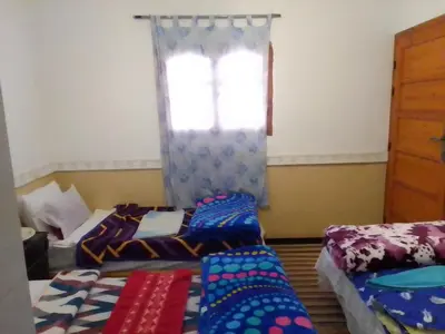 a room with two beds and a window at Hotel restaurant ait saderat in Boumalne