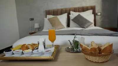 a tray of food on a table next to a bed at Hotel Riad Taounate in Taounate
