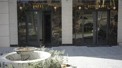 a building with a fountain in front of a hotel at Hotel Riad Taounate in Taounate