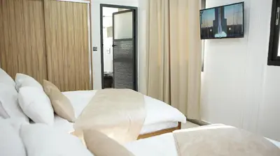a hotel room with a bed and a television at Hotel Riad Taounate in Taounate
