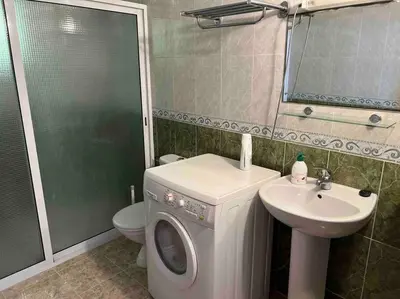 a bathroom with a washing machine and a sink at Appartement chaleureux Azrou in Azrou