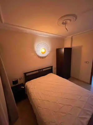 a bedroom with a bed with a light on the ceiling at Appartement chaleureux Azrou in Azrou