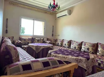 a room with couches and tables and a window at Appartement chaleureux Azrou in Azrou