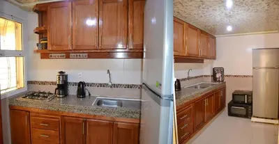 a kitchen with wooden cabinets and a stainless steel refrigerator at holiday apartment rental in Meknès