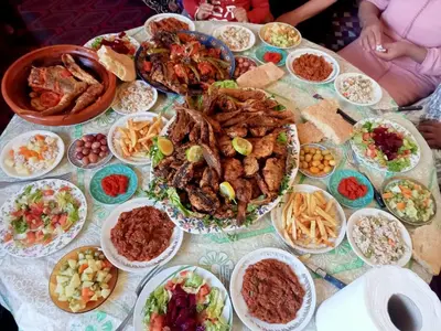 a table with many plates of food on it at holiday apartment rental in Meknès