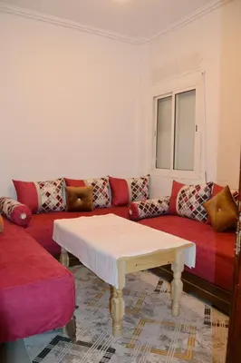 a living room with a couch and a table at holiday apartment rental in Meknès