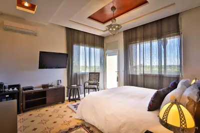 a bedroom with a large bed and a flat screen tv at Palais Amador in Marrakech