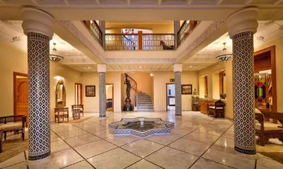 a large lobby with columns and a table in the middle at Palais Amador in Marrakech