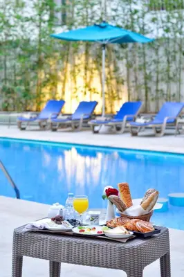 a table with food and drinks next to a pool at Fes Heritage Boutique luxury Hotel in Fès
