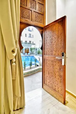 an open wooden door with a view of a pool at Fes Heritage Boutique luxury Hotel in Fès