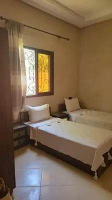 a bedroom with two beds and a window at Villa privative tortues2 piscine chauffée 35min Marrakech in Marrakech