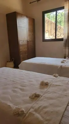 a bedroom with two beds and a window at Villa privative tortues2 piscine chauffée 35min Marrakech in Marrakech