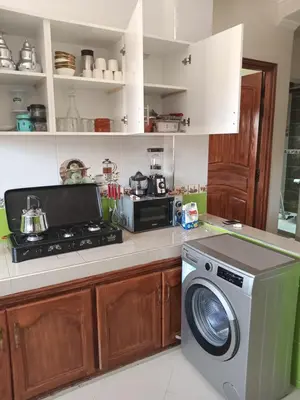 a kitchen with a stove and a washing machine at Résidence Jannat in Ouarzazate