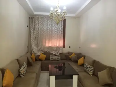 a living room with a couch and a chandelier at Résidence Jannat in Ouarzazate