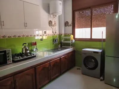 a kitchen with a sink and a washing machine at Résidence Jannat in Ouarzazate