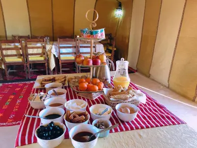 a table with bowls of food and other foods at Luxury Camp Camelhouse in Merzouga