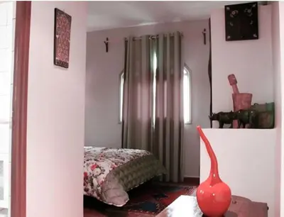a bedroom with a bed and a red vase on the floor at Kasba Oum Hani d'Ouzoud in Ouzoud