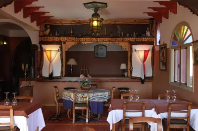 a dining room with two tables and a mirror at Kasba Oum Hani d'Ouzoud in Ouzoud