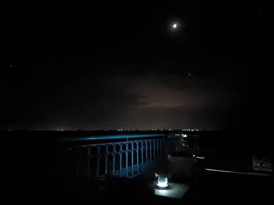 a night time view of a balcony with a moon at Villa Andaloussya, Majorel Host in Aït Ourir