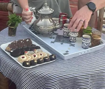 a person sitting at a table with a tray of food at Villa Andaloussya, Majorel Host in Aït Ourir