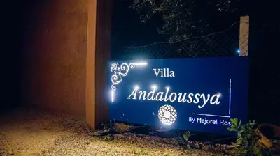 a blue sign with lights on a fence at Villa Andaloussya, Majorel Host in Aït Ourir