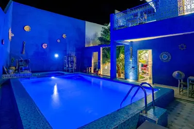 a large swimming pool with blue lighting in a house at Villa Andaloussya, Majorel Host in Aït Ourir