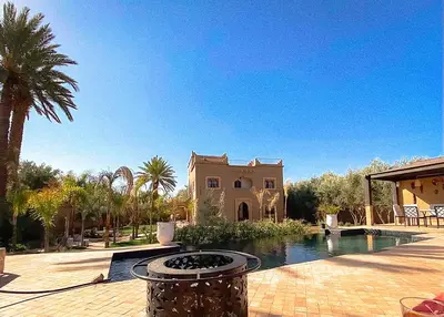 a house with a swimming pool in front of a house at Dar Lily, villa familiale avec piscine et services in Skoura