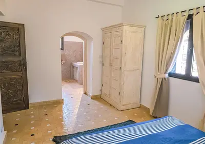 a bedroom with a bed and a dresser and a window at Dar Lily, villa familiale avec piscine et services in Skoura
