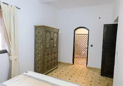 a room with a large wooden cabinet and a door at Dar Lily, villa familiale avec piscine et services in Skoura