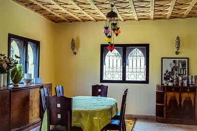 a dining room with a table and a window at Dar Lily, villa familiale avec piscine et services in Skoura