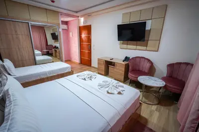 a hotel room with two beds and a television at FEKRI HOTEL in Meknès