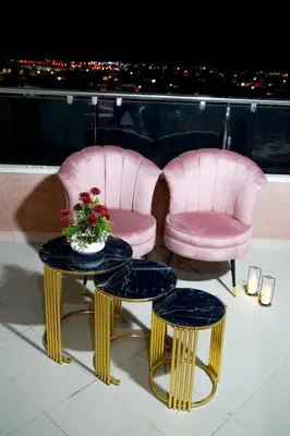 two pink chairs and a table with flowers on a balcony at FEKRI HOTEL in Meknès