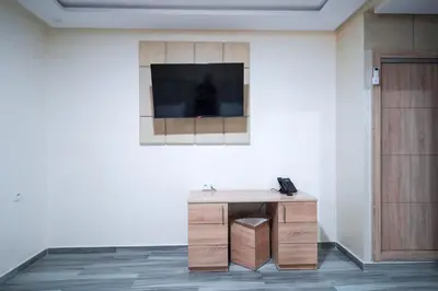 a desk in a room with a television on a wall at FEKRI HOTEL in Meknès