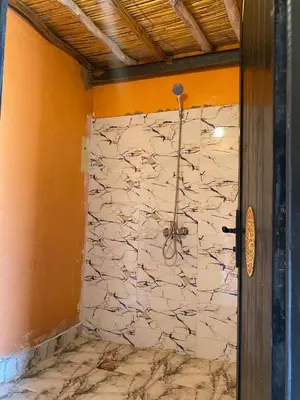 a room with a stone wall with a wall at Desert Erg Chegaga Camp in El Gouera