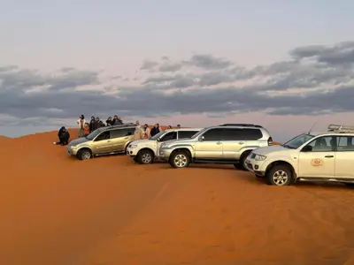 a group of cars parked in the desert at Luxury Desert Central Camp in Merzouga