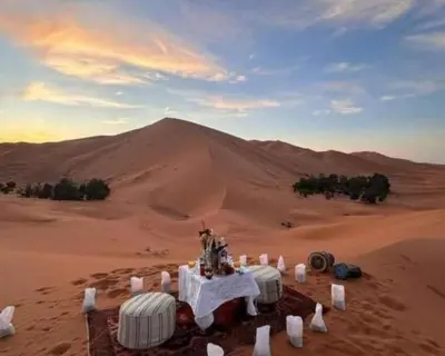 a table in the desert with a mountain in the background at Luxury Desert Central Camp in Merzouga