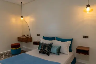 a bedroom with a bed with blue and white pillows at Imlil apartment climatisé in Azrou
