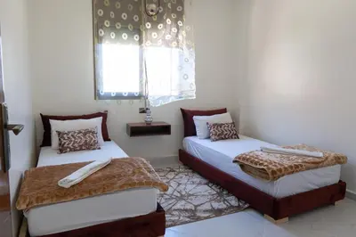 a bedroom with two beds and a window at Imlil apartment climatisé in Azrou