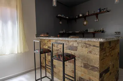 a bar with two stools in front of a counter at Imlil apartment climatisé in Azrou