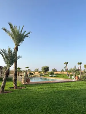 a park with palm trees and a swimming pool at Villa Beij in Marrakech
