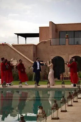 a group of people standing around a swimming pool at Villa Beij in Marrakech